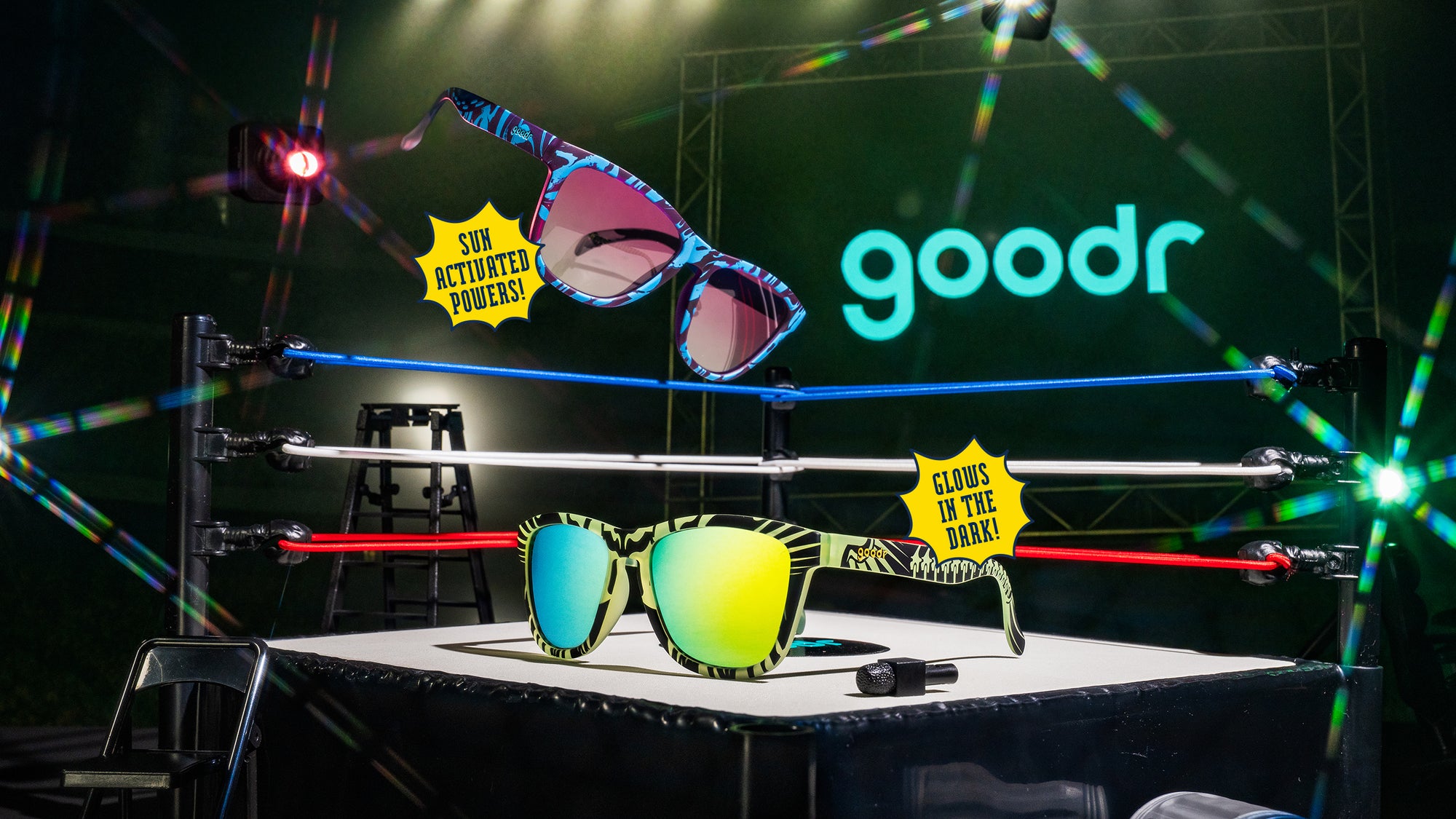 Colorful sunglasses on a stage with 'goodr' branding and light effects.