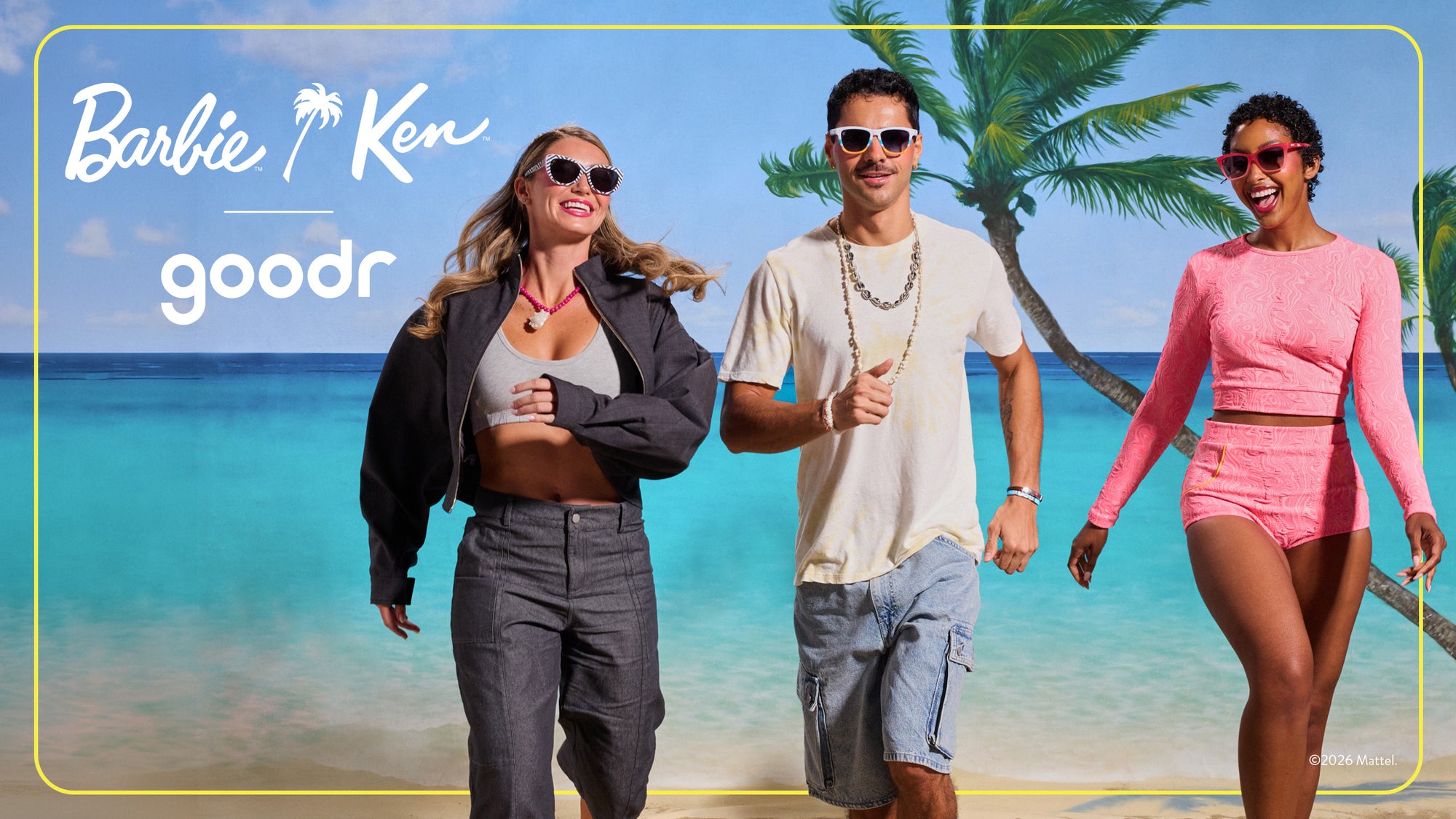 Three people walking on a beach with palm trees and ocean in the background, featuring the Barbie and Ken Goodr logo.