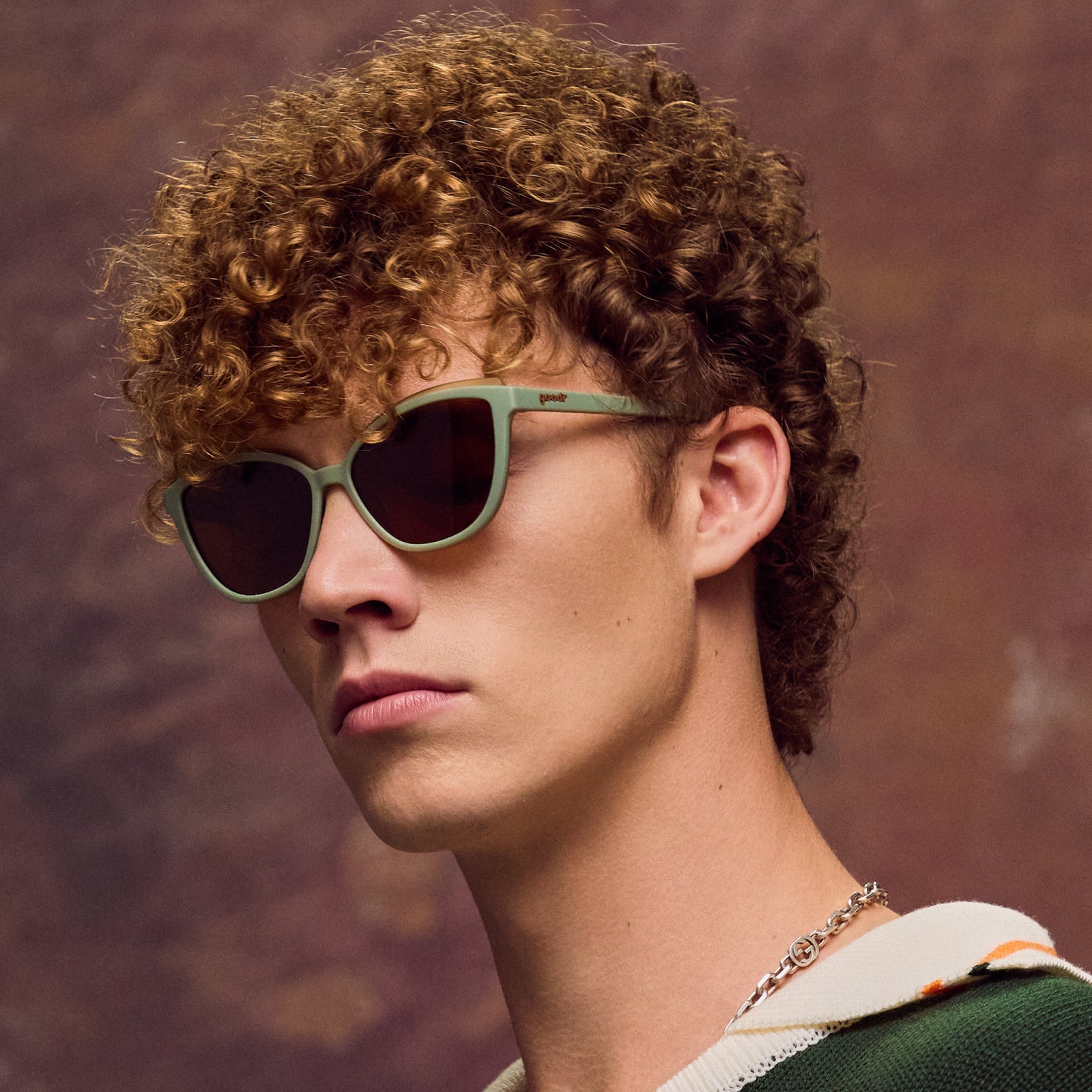 Person wearing sunglasses with a warm-toned background