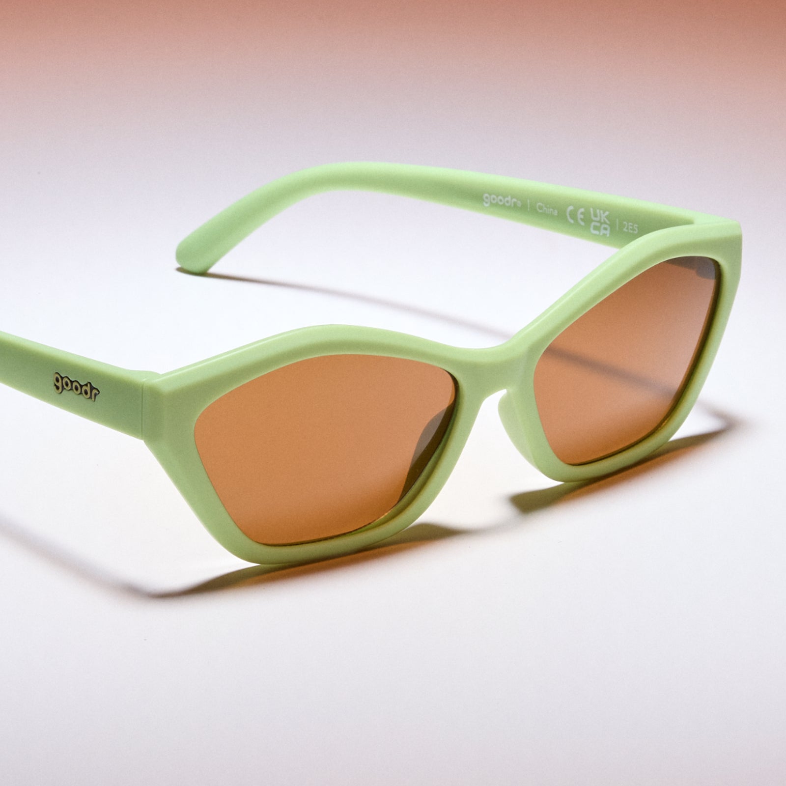 Green sunglasses with brown lenses on a white background