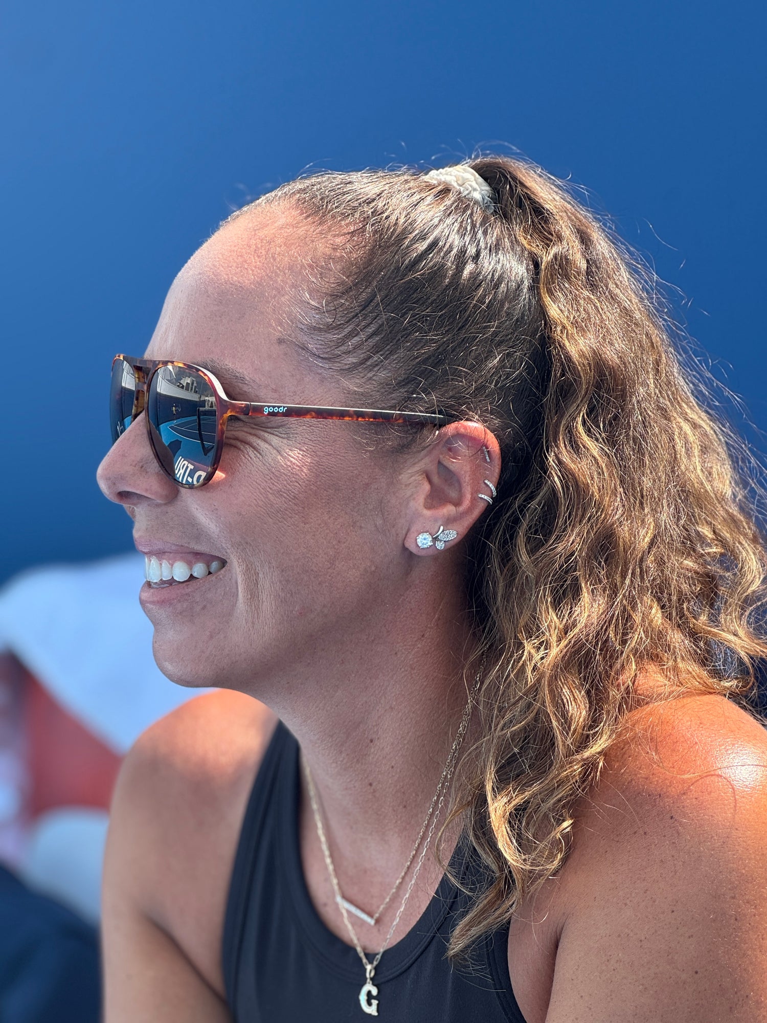 Woman wearing goodr sunglasses with a blue background