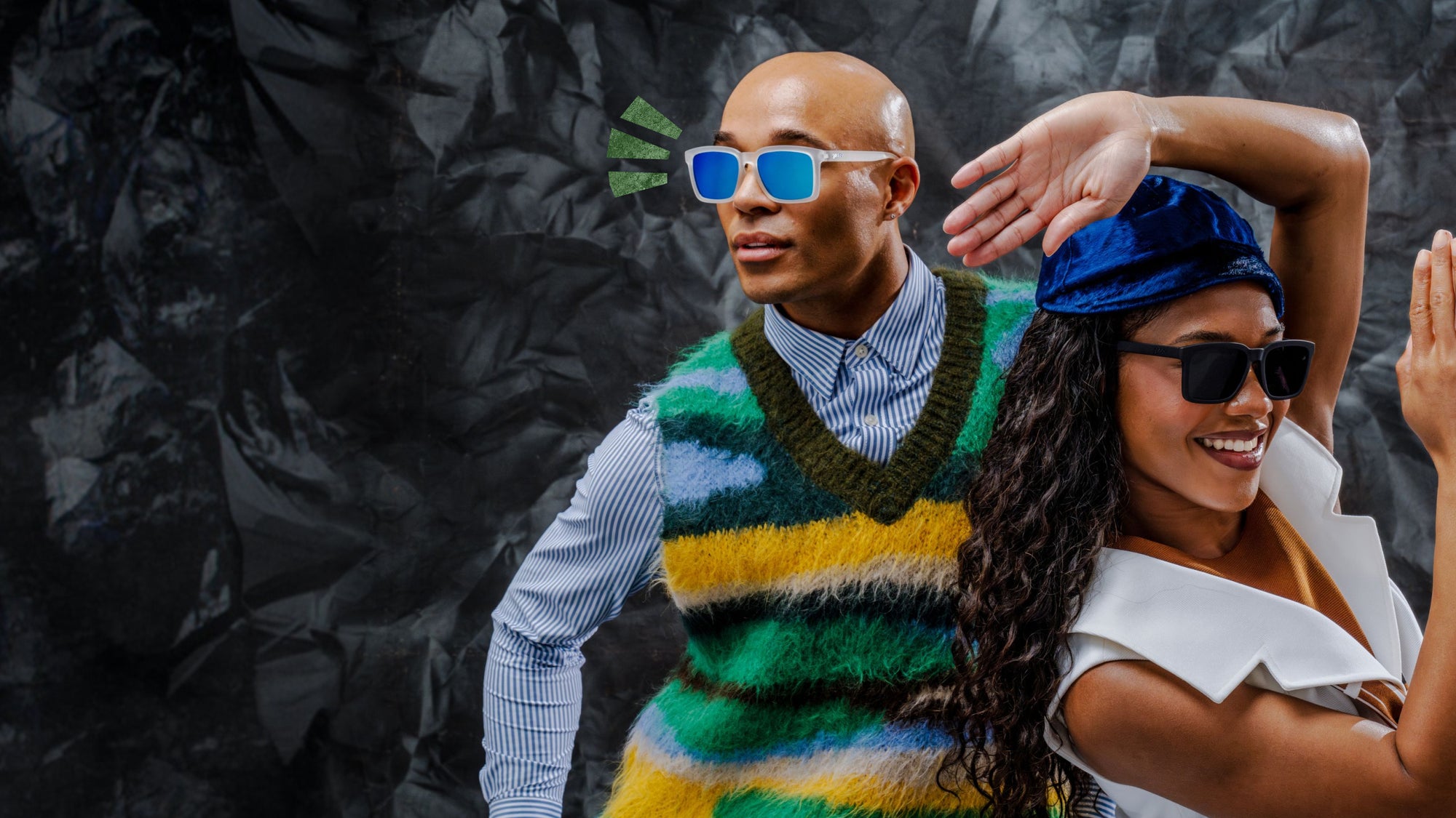 Two people posing against a dark, textured background