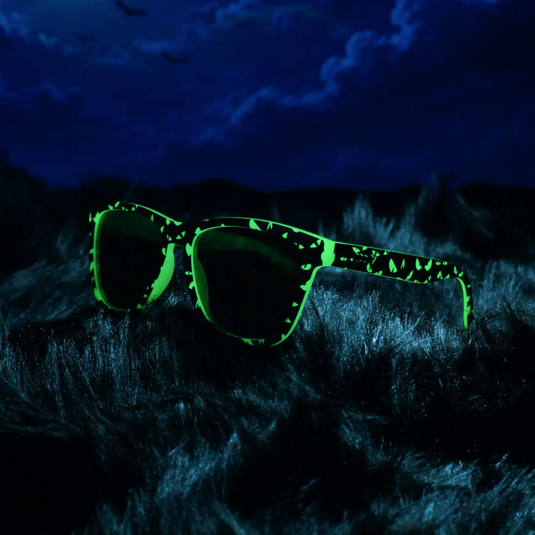 Creatures seem to peer through the darkness from these glow-in-the-dark shades posed against a spooky nightscape backdrop.