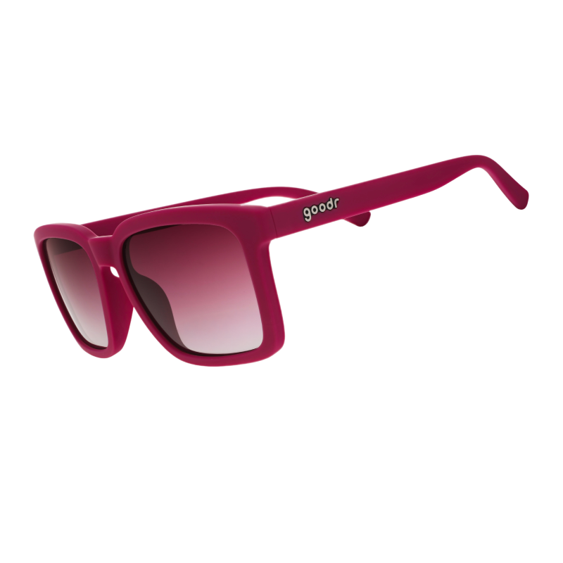 Three-quarter angle view of purple sunglasses w/ a square silhouette & purple gradient lenses tilted down.