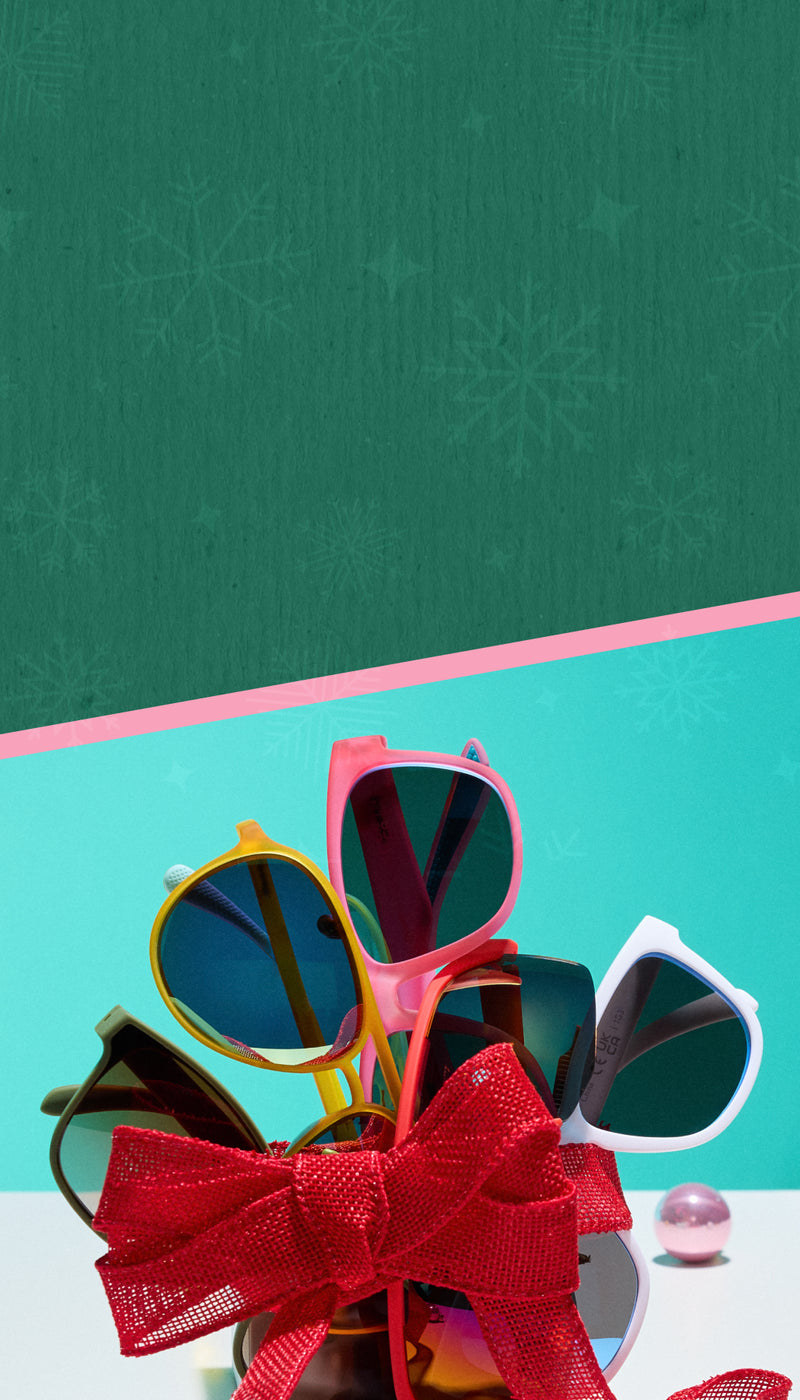 Colorful sunglasses with a red bow on a green and blue gradient background