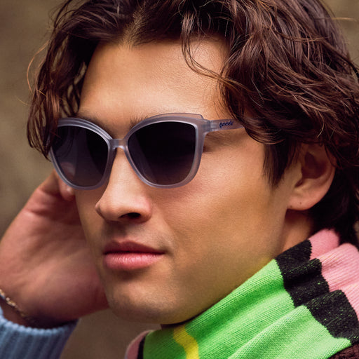 Close-up of a person wearing sunglasses with a colorful sweater