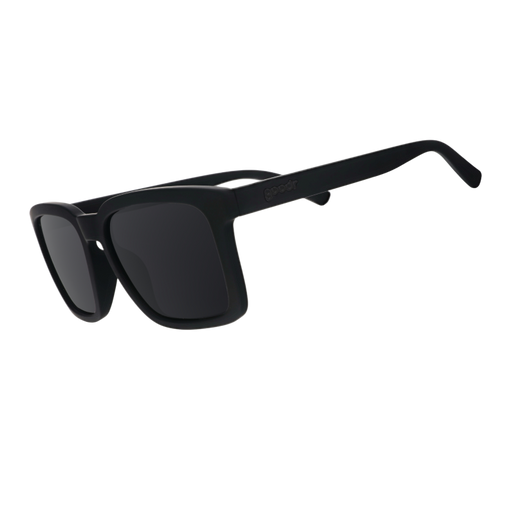 Three-quarter angle view of black sunglasses w/ a square silhouette & black nonreflective lenses tilted down.