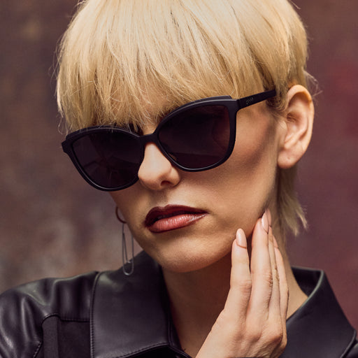Woman wearing black sunglasses with a blurred background
