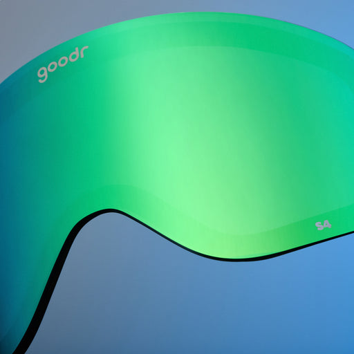 Close-up of bright green mirrored goodr replacement lens against a blue background.