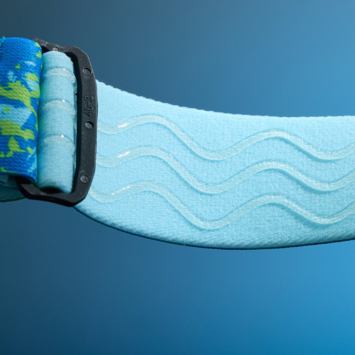 Close-up of light blue elastic goggle strap with raised wavy silicone grip lines.