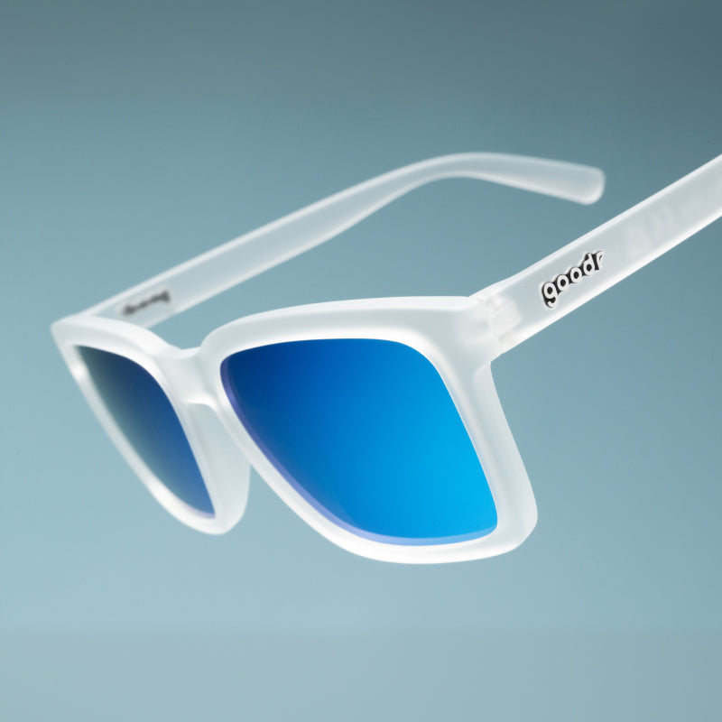 Three-quarter angle close-up view of translucent clear shades with a square silhouette & light blue reflective lenses.