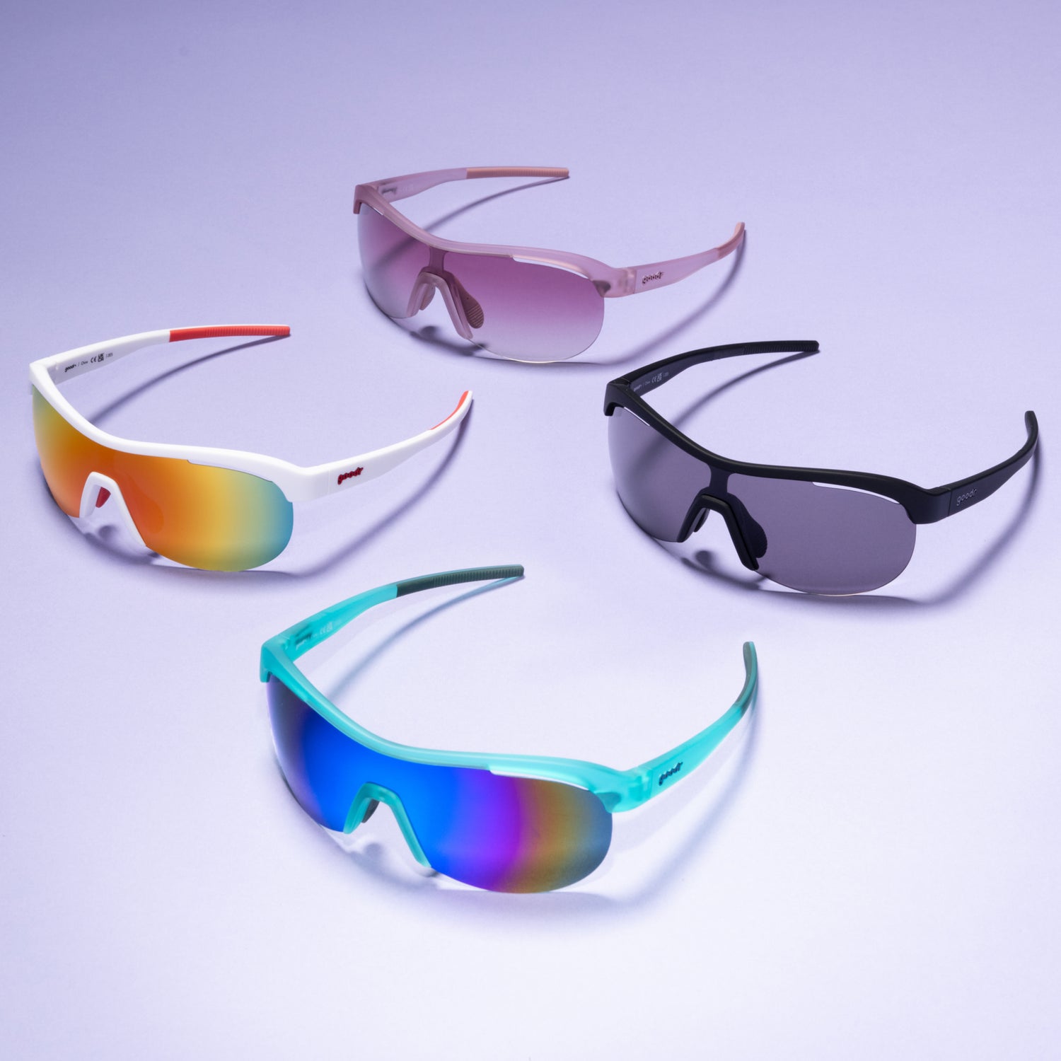 Four pairs of colorful sunglasses on a light purple background