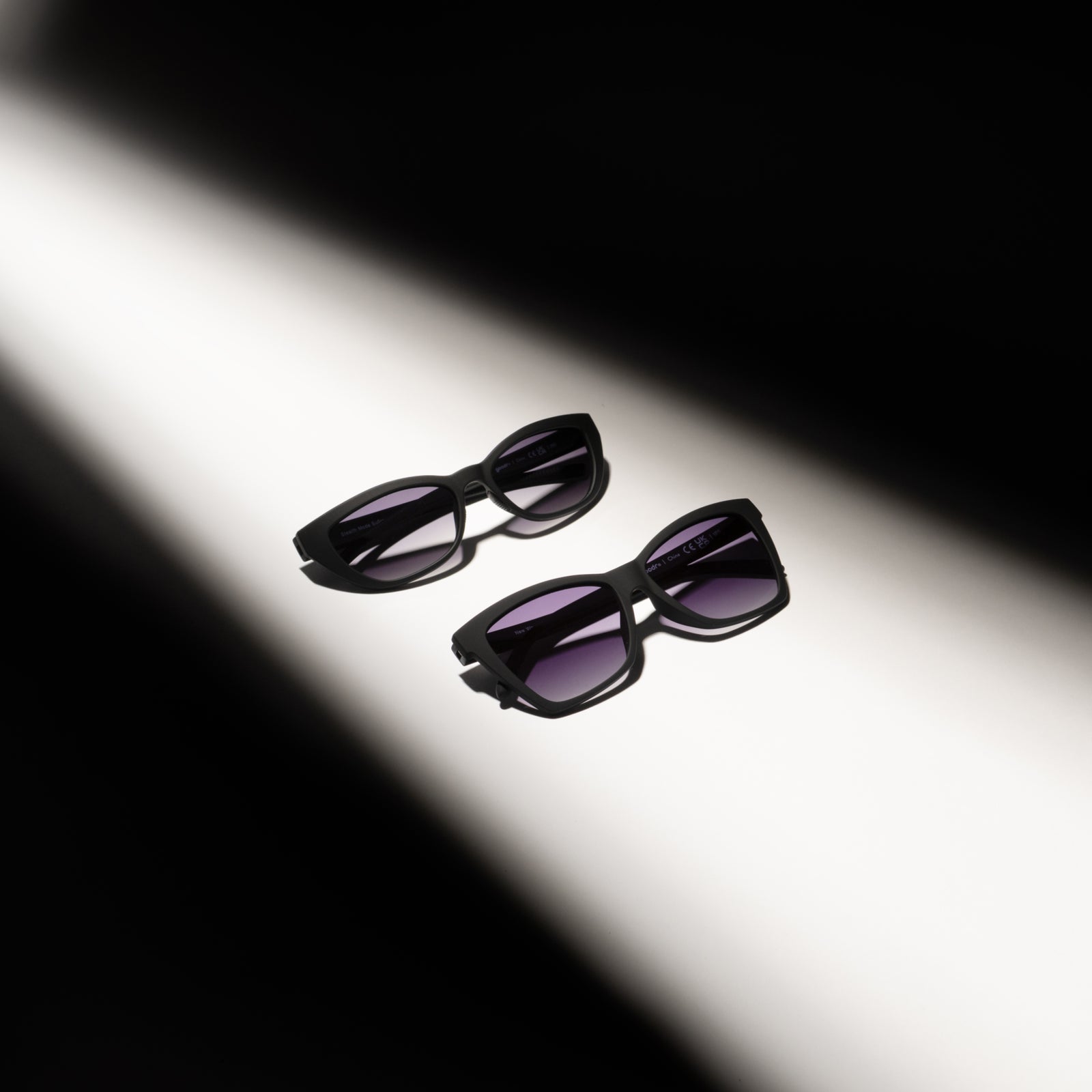 Black sunglasses with purple lenses on a white background