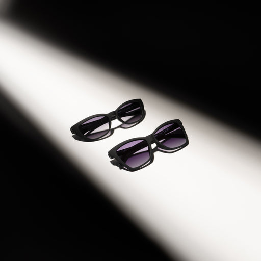 Black sunglasses with purple lenses on a white background