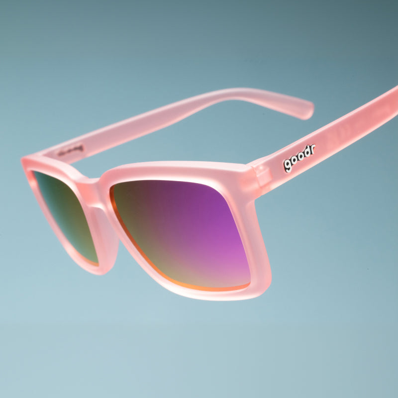 Angled close-up view of translucent light pink square shades with pink reflective lenses & a classic square silhouette.