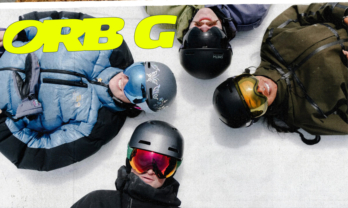 Four people lying down on snow wearing helmets and goggles, with a large yellow 'ORB G' logo overlay in the top left corner.